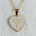 Golden heart necklace with white shell inlay featuring the letter Y on a linen background - Letter Y / Gold