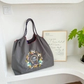 Close-up of refined horse embroidery and brand logo on a grey waterproof nylon tote bag - Grey Horse Racing