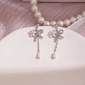 Vue détaillée de boucles d'oreilles fleurs roses à pompons avec strass sur socle blanc - Nœud Chaîne Argenté