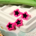 Detailed view of pink star-shaped doll glasses earrings on white display tray - Rose Red