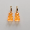 Macro view of orange gummy bear earrings with gold hooks and sparkling crystals - Transparent Orange