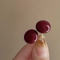 Close-up of deep red circular stud earrings with a glossy finish and metallic needles - Dark Red Shiny Ball (80# Silver Needle)