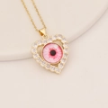 Detailed view of a gold heart pendant with CZ stones and a pink eye motif on a thin chain - Pink Textured Eye (6#)