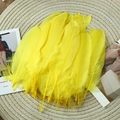Close-up of bright yellow goose feathers on a woven mat for DIY craft decorations - Stiff Yellow (50Pcs)