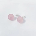 Close-up of pink quartz silver stud earrings with clear silicone backs on white surface - 6mm Rose Quartz / Pink With Silicone Backs
