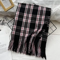Classic black, white, and red checkered scarf with fringed edges on a display rack - Black