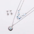 Macro view of silver evil eye necklace and matching ball stud earrings jewelry set - Steel White