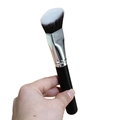Angled foundation brush with black handle and gradient bristles shown being held - Angled Foundation Brush / Black