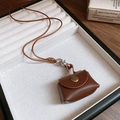 Nahaufnahme einer braunen Leder-Mini-Tasche als Halskette auf einem Schmucktablett - 4# Leder Mini Tasche Halskette