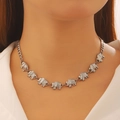 Detail shot of a silver elephant pendant necklace worn by a model for Mother's Day - White K