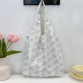 Close-up of floral tote bag with cute bear pattern hanging on a white wall hook - Rose Bear
