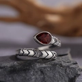 Macro shot of S925 silver snake ring with red garnet stone on dark rock base - Natural Garnet Snake Ring LR288