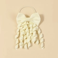Dettaglio di un fiocco in nastro grosgrain crema con riccioli a spirale per bambine - Beige