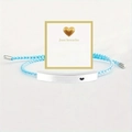 Macro shot of blue woven bracelet with engraved 'Just breathe' metal bar and gift card - Just Breathe Silver Bar Lake Blue Rope With Card