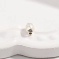 Macro d'une perle intercalaire irrégulière en argent S925 sur un plateau blanc - 4.5*5.5mm / Argent Petit