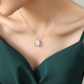 Elegante ketting met kattenoogsteen hanger in zilver gedragen door vrouwelijk model - Grote witte hanger / Staalkleur