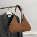 Bolso de ante esmerilado marrón colgado en una percha junto a una chaqueta de traje - Marrón