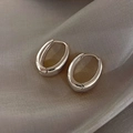 Close-up of polished silver oval hoop earrings on elegant grey silk fabric - Silver Mirror Oval Hoop (E015)