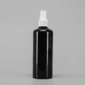 Detail view of a black glossy plastic spray bottle with white pump and clear safety cap - 300ml / Black Bottle