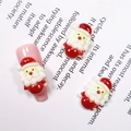 Makro-Detail von Cartoon-Weihnachtsmann-Nagelanhängern aus Harz auf rosa Kunstnagel - #304