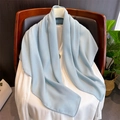 Texture dettagliata di una sciarpa in cotone e lino azzurro drappeggiata su camicia bianca - 90x90cm / Azzurro
