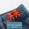 Pair of coral orange mini bear jean buttons for waist tightening on blue denim fabric - Hand-sewn Bear / Coral Orange