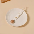 Détail de l'attache-tétine en coton fleuri avec clip en bois de hêtre sur une assiette - Style Floral Blanc (3)