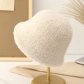 Detail of beige fleece bucket hat texture on a golden display stand in a cozy setting - Off-white