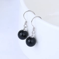 Elegant drop earrings featuring round black agate beads on silver hooks displayed on ceramic - 925 Silver / Black Agate Earrings