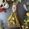 Detailed view of a handmade decorative broom with blue crystal and dried yellow flowers - Broom+Flowers+Apatite