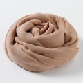 Linen-cotton scarf in dusty pink color, elegantly folded into a rose shape for display - Pale Pink