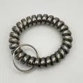 Close-up of a matte dark grey spiral phone cord keychain with a silver metal ring connector - Metallic Black