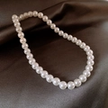 Elegante collana di perle bianche tonde e lucide su sfondo di raso marrone scuro - 40# Collana-Bianco 10mm