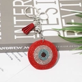 Glitzernder Evil Eye Schlüsselanhänger mit blauen Strasssteinen und roter Wildlederquaste - Rot