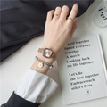 Detail of rose gold square watch and daisy bracelet on wrist with elegant lifestyle decor - Rose Gold Case White Dial