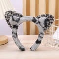 Close-up of plush grey leopard print cat ear headband on a minimalist wooden surface - Grey Leopard Print