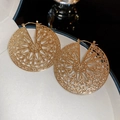 Makroaufnahme goldener runder Ohrringe mit feinem durchbrochenem geometrischem Muster - Creolen-Verschluss-Stil / Gold