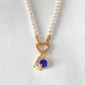 Elegant pearl necklace with heart clasp, blue gemstone and golden fan charm pendants - Letter L
