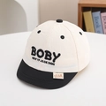 Detailed close-up of baby baseball cap with BOBY embroidery and flat black brim - 50cm (1-3 Years) / White