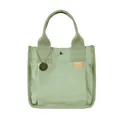Borsa tote in tela verde chiaro con grande tasca frontale e ciondolo in metallo inciso - verde chiaro
