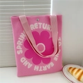 Close-up of pink knitted tote bag showing magnetic buckle and floral print detail - Pink Flower