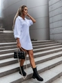 Detail of white button-up shirt dress with lapel collar worn by a model on stone steps - S / White