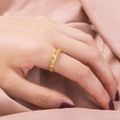 Close-up of elegant gold ring with a row of sparkling cubic zirconia on pink silk - Retro Beaded Hollow