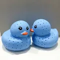 Vue macro de deux infuseurs à thé canard en silicone bleu avec des becs orange et trous - Canard Bleu