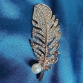 Elegant gold feather brooch with sparkling crystals and a white pearl on blue silk - Pearl Feather Brooch
