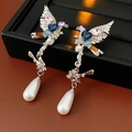 Detailed macro view of vintage bird earrings with colorful crystals and pearl drops - Silver Earring Post Earrings - Silver Multi-color