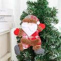 Dettaglio di un Babbo Natale di peluche appeso ai rami verdi di un albero di Natale - Babbo Natale
