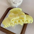Détail de la pince à cheveux en acétate jaune marbré sur un plateau en bois - 9.7cm / Jaune