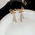 Close-up of gold bow earrings with sparkling stones and dangling pearl tassels - 18# Silver Earring Post - Gold Rhinestone Bow Pearl Tassel