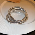 Dettaglio del bracciale elastico in metallo argentato a tre strati con trama a lisca di pesce - Stile Largo a 3 Strati / Argento